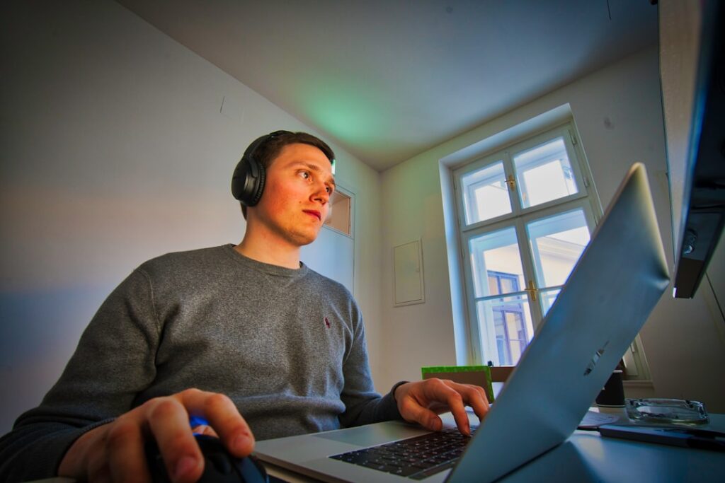 young man laptop programming home study