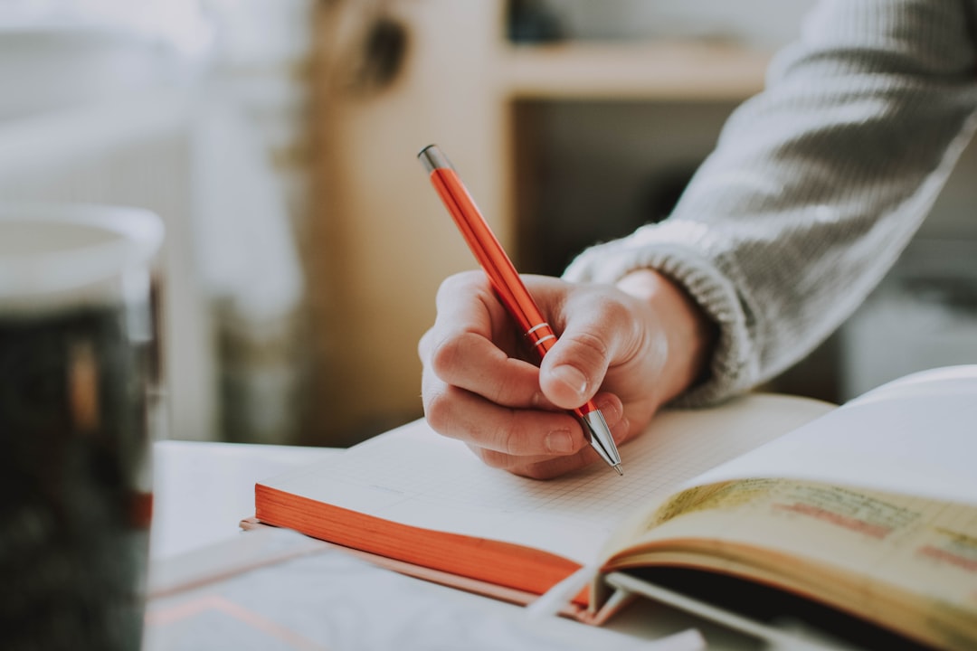 person writing notebook reflection