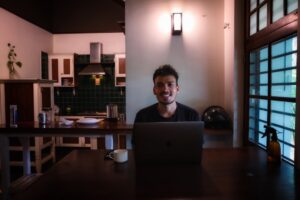 young man studying laptop at home night