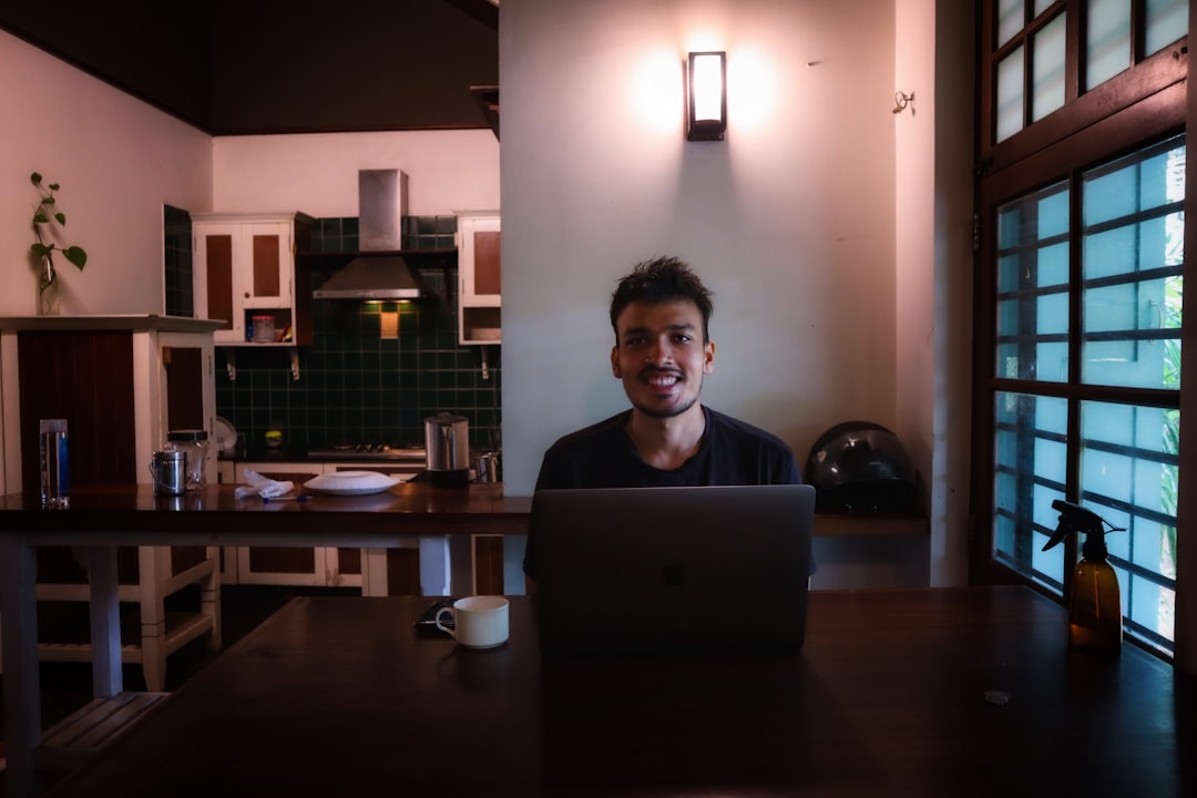 young man studying laptop at home night