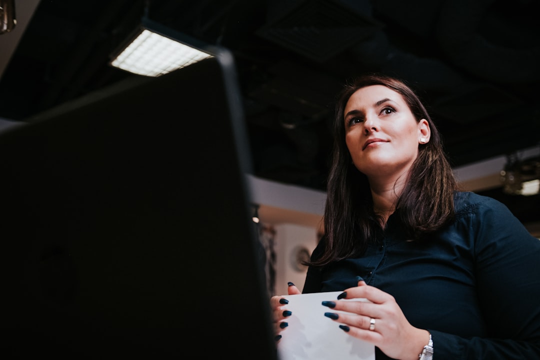 business woman comparing documents laptop