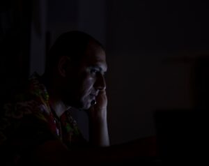 japanese man frustrated looking at laptop late night