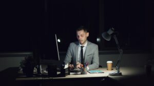 businessman studying certification books at night desk