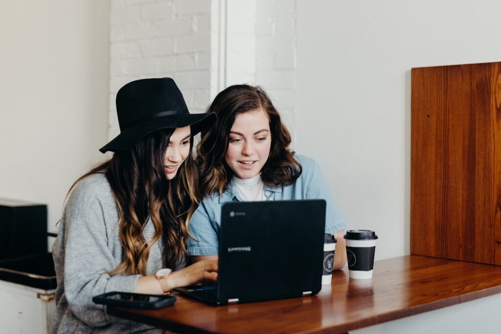 two people comparing laptop programming