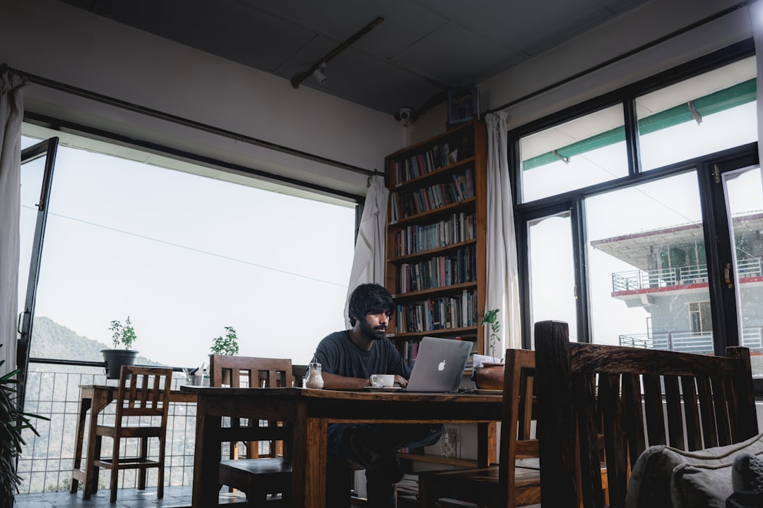japanese man writing notes in notebook at home cafe