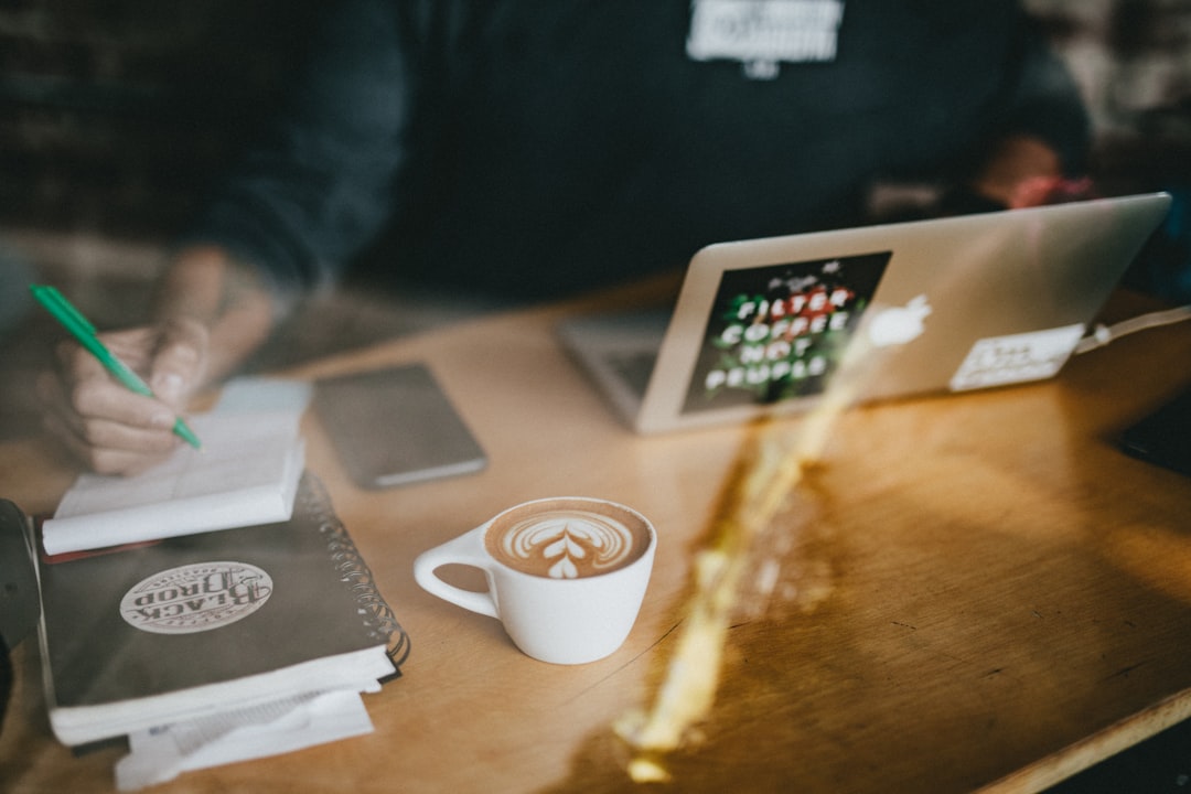 person practicing writing notebook coffee