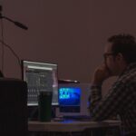 tired man laptop editing video late night