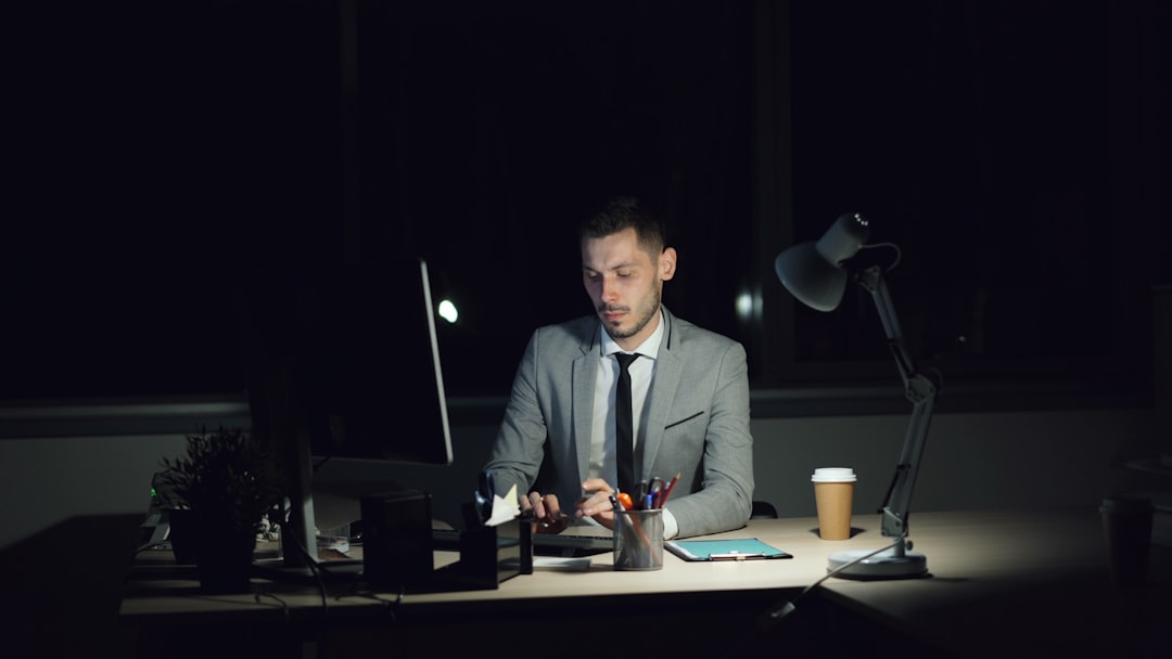 tired businessman desk lamp late night work
