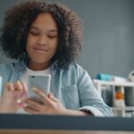 woman using smartphone social media at home desk