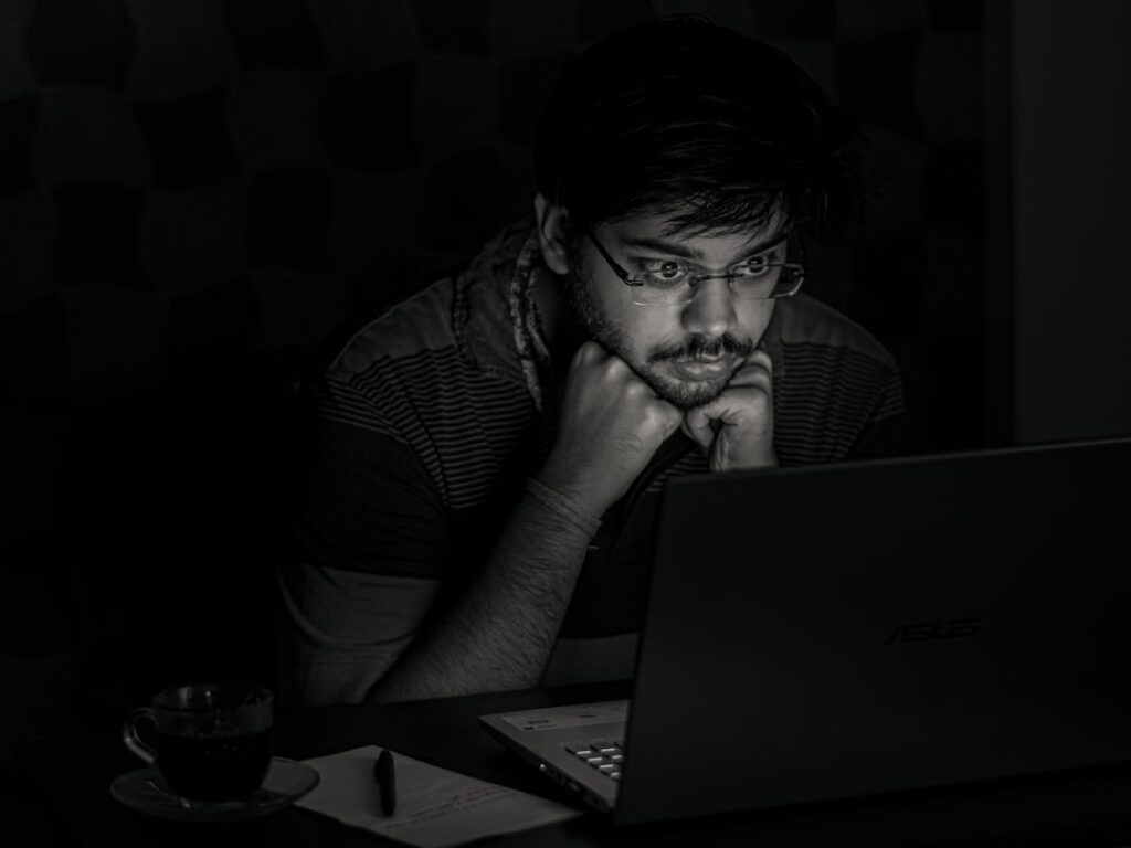 worried businessman looking at laptop at night