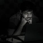 worried businessman looking at laptop at night