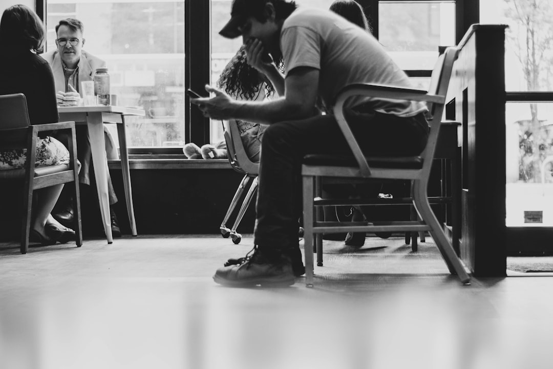 person reading reviews smartphone cafe