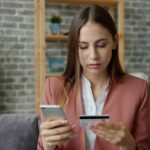 woman calculating budget smartphone home night