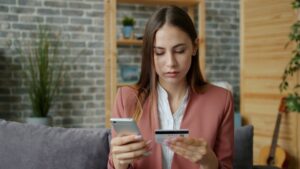 woman calculating budget smartphone home night