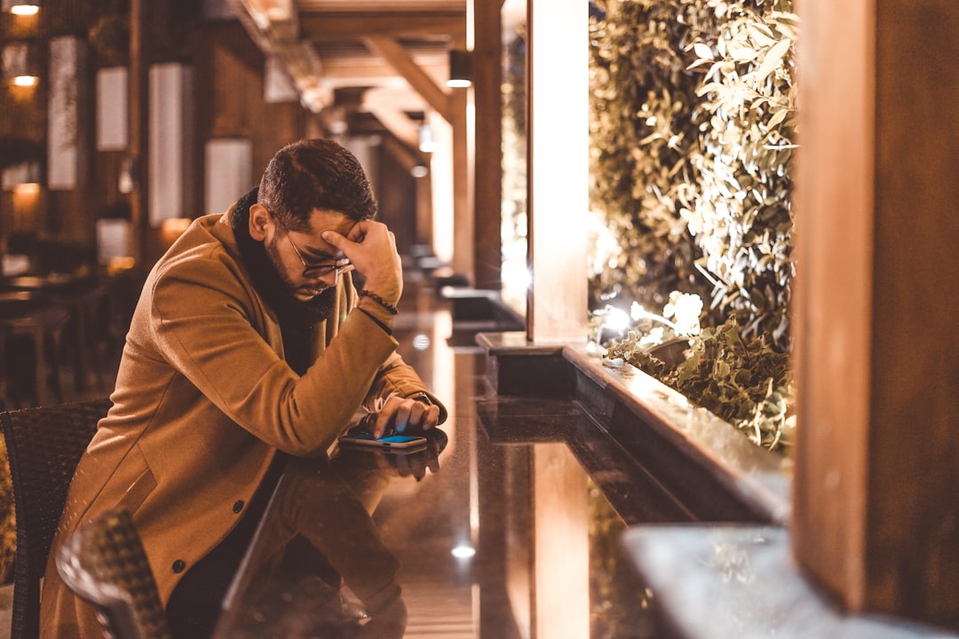 tired businessman looking at smartphone night