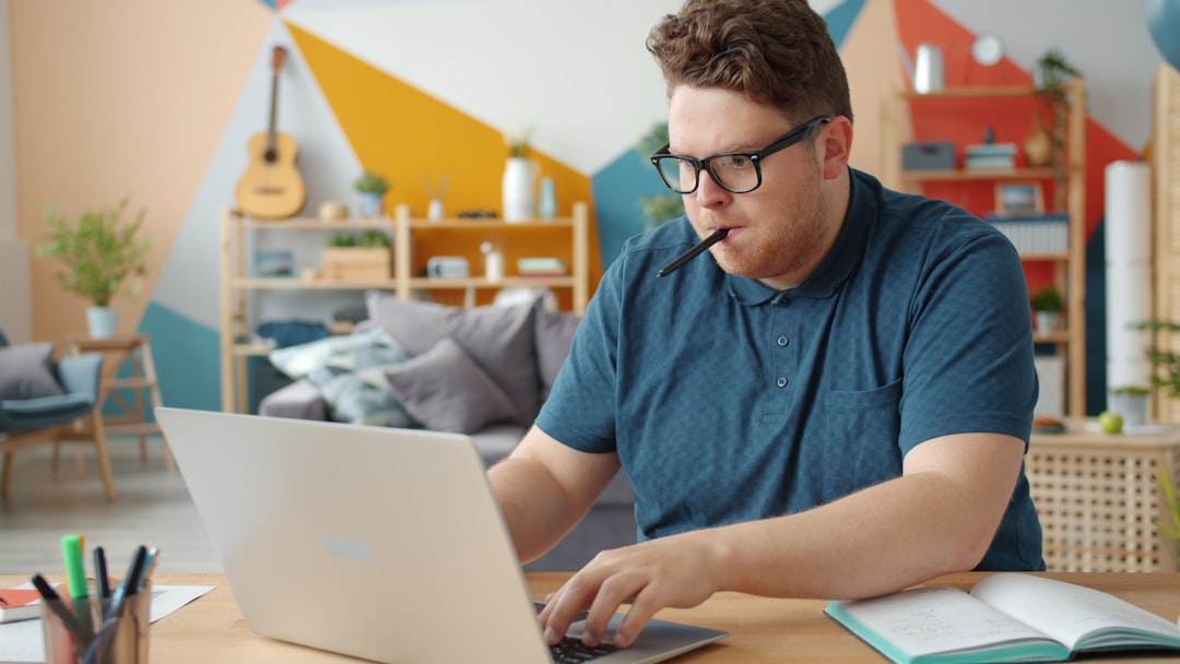 focused man studying laptop apartment desk