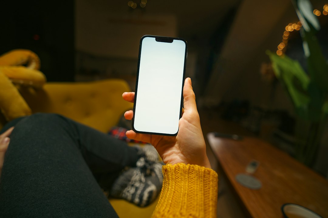 woman using smartphone on sofa at night