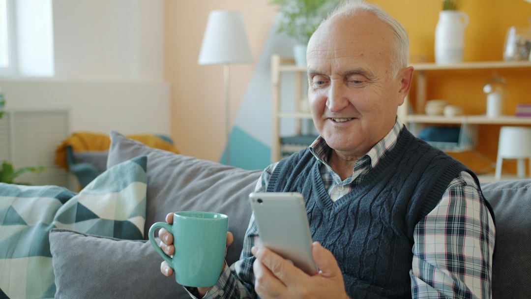 smiling man using smartphone in living room