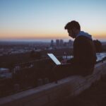 man studying cloud computing laptop night