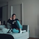 woman using smartphone on sofa at night