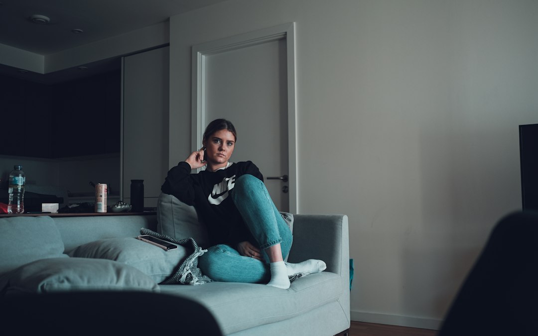 woman using smartphone on sofa at night