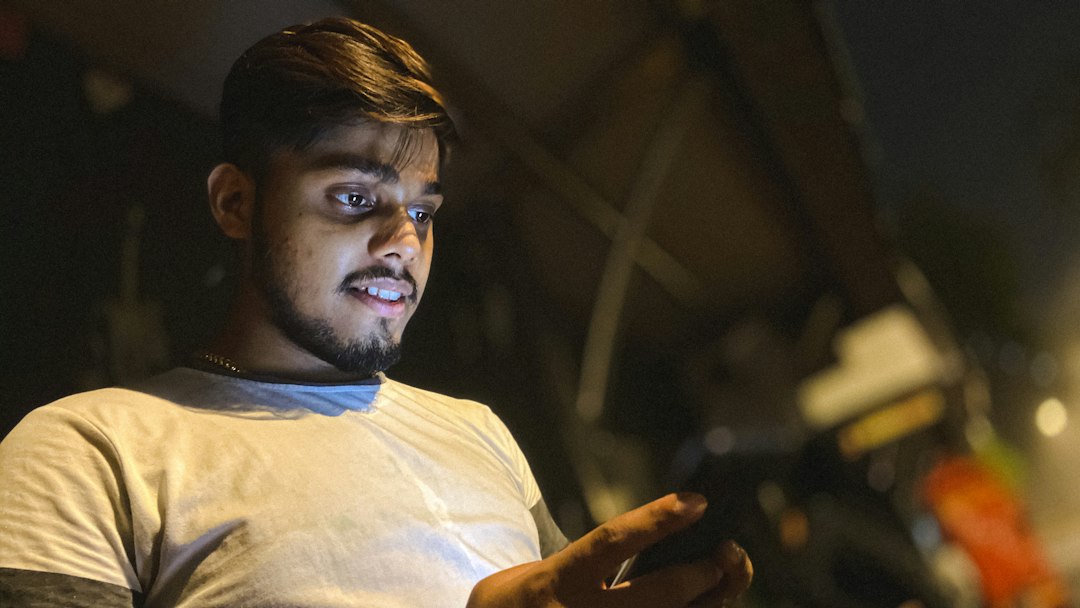 frustrated man looking at smartphone late night