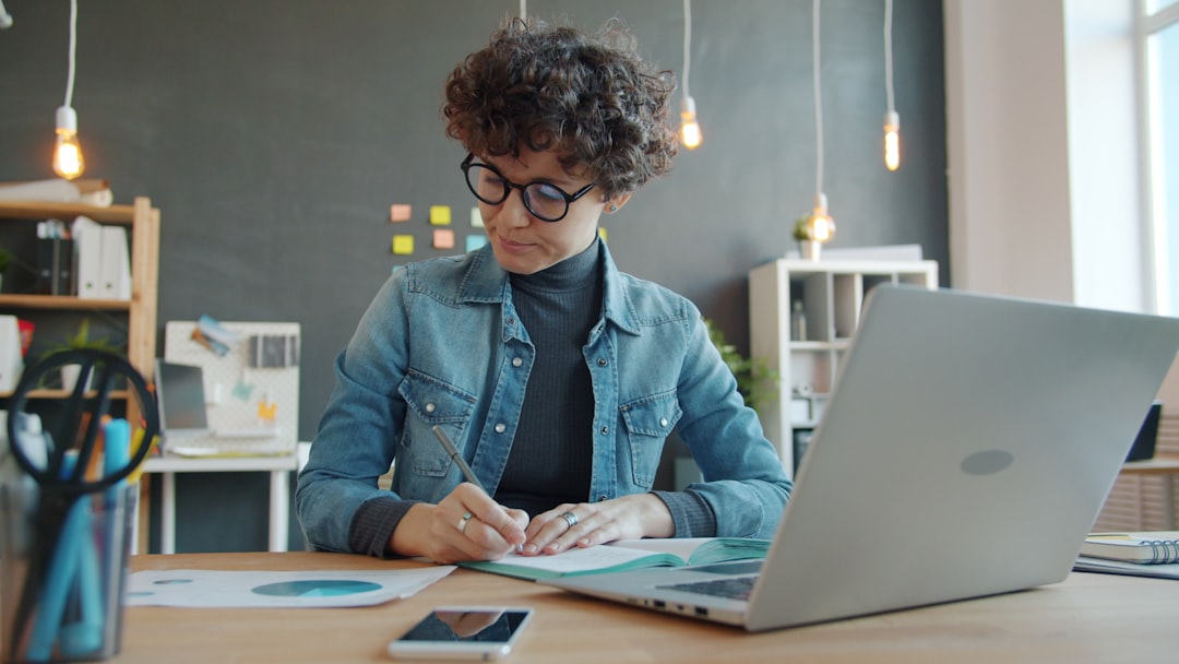 person writing notes notebook desk